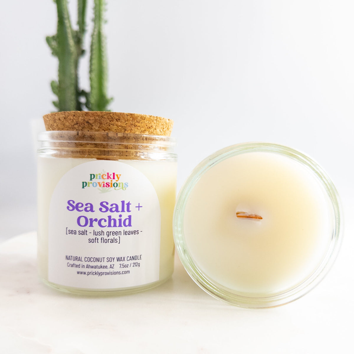 Candle labeled 'Sea Salt + Orchid' by Prickly Provisions with a cork lid on a white background.