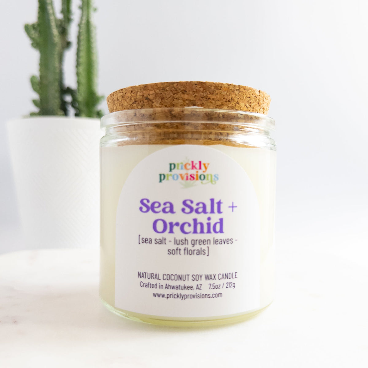 Jar of 'Sea Salt + Orchid' candle with a cork lid on a white background