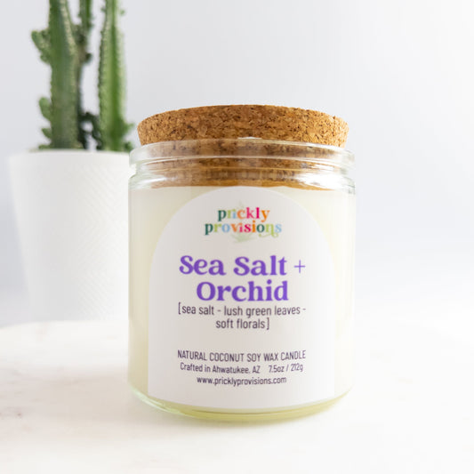 Jar of 'Sea Salt + Orchid' candle with a cork lid on a white background