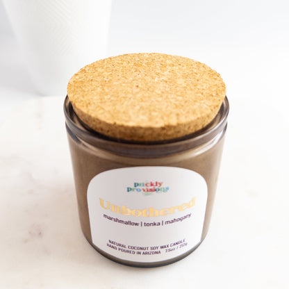 Candle jar with cork lid and 'Prickly Provisions' label on a white background