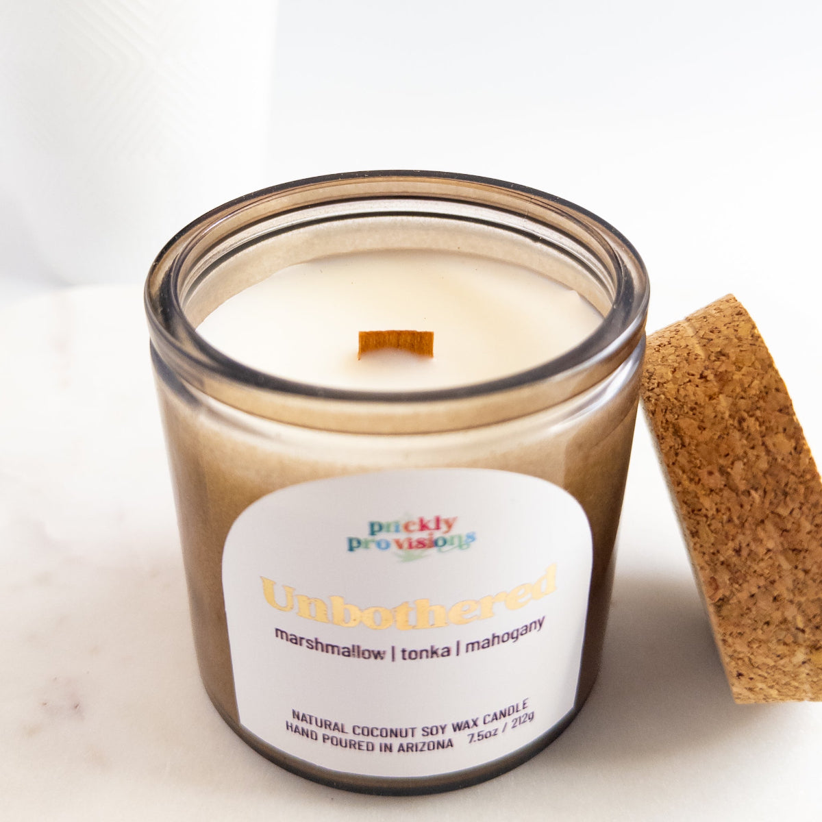 Candle in a glass jar with a label on a white background