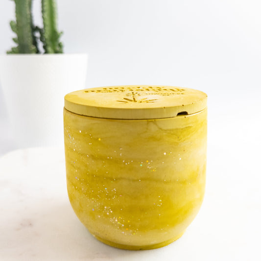 Yellow green marble-patterned container with lid on a white surface