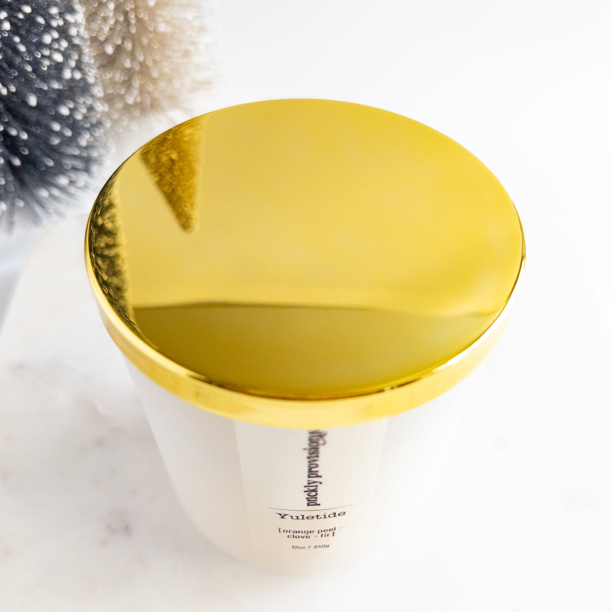 Gold-topped container with a white label on a light background